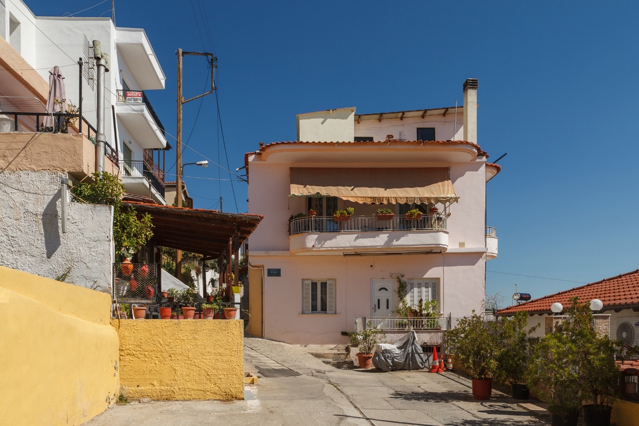 Fachada de casa rosa com porta de entrada — metáfora visual da marca Pórtico